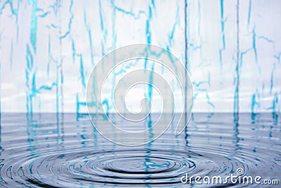 Splash and ripples on water from falling raindrop on light wooden background with peeling paint Stock Photo