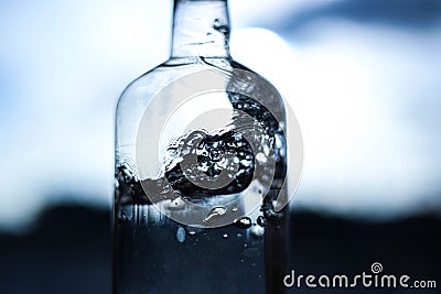 A splash of water in a bottle close-up on a dark, light background. Water details. Water structure Stock Photo