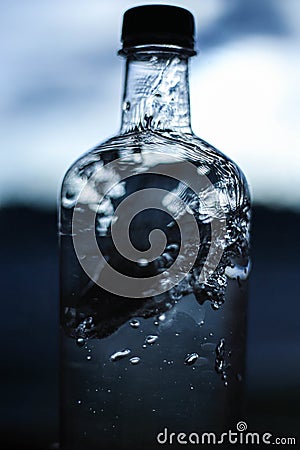 A splash of water in a bottle close-up on a dark, light background. Water details. Water structure Stock Photo