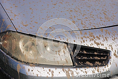 Splashes of mud. Close up of a dirty headlight of gray car with muddy splash. Car wash concepts. - Background texture Stock Photo