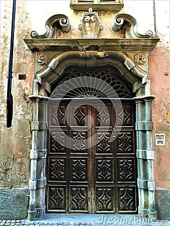 Splendid ancient door and wall in Saluzzo town, Piedmont region, Italy. History, enchanting architecture and art Stock Photo