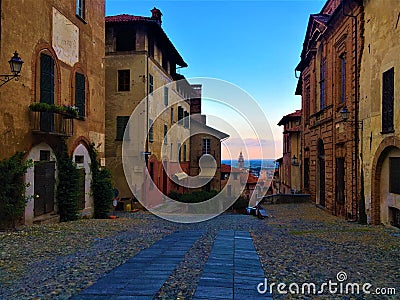 Splendid ancient street in Saluzzo town, Piedmont region, Italy. Colours, history, enchanting architecture and art Editorial Stock Photo