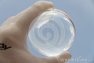 Cloud reflected in a crystal ball in a gloved hand Stock Photo