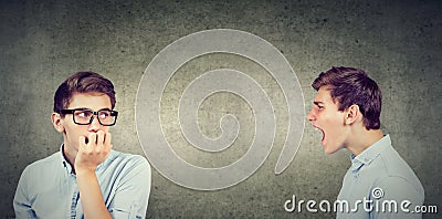 Split personality. Angry young man screaming at scared anxious himself Stock Photo