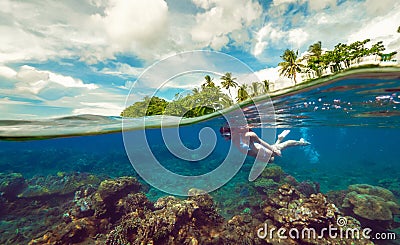 Split underwater photo of a girl snorkeling with mask in tropical ocean enjoying summer vacation on exotic island Stock Photo