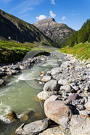 Spol River flowing in Lake Livigno, Corno Brusadella Mountain background Stock Photo
