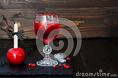 Spooky bloody cocktail and red caramel apple. Traditional dessert and drink recipe for Halloween party. Selective focus. Copy spac Stock Photo