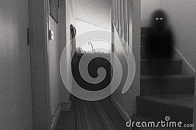 A spooky ghost with glowing eyes standing on a staircase. With a black and white, grainy edit Stock Photo