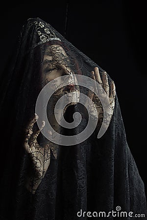 Spooky, Gothic image of woman with black lace over her face Stock Photo