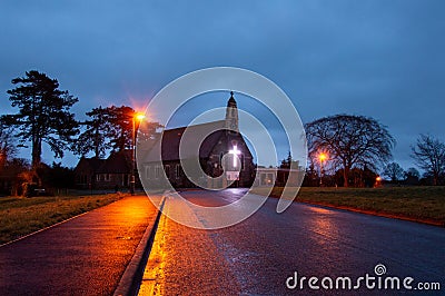 A spooky old Victorian church with a glowing cross on a winters night Stock Photo