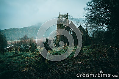 Spooky ruined church surrounded by a graveyard on a misty winters day in the English countryside Stock Photo