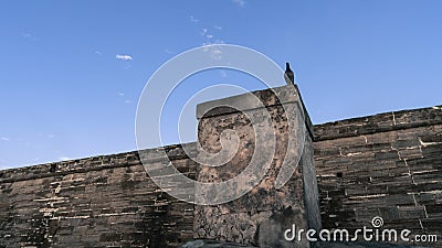 Spooky scene with a bird standing on a old historic fort wall. Stock Photo