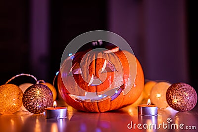 Spooky smiling halloween pumpkin in burning fire candles flames. Stock Photo