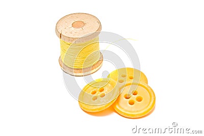 Spool of yellow thread and plastic buttons Stock Photo