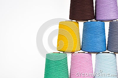 Spools of multicolored cotton thread on a white background lined up in a pyramid with space for text Stock Photo