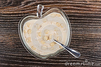 Spoon in yogurt with oat bran in bowl on table Stock Photo