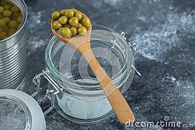 Spoon olive over empty jar on grey background Stock Photo