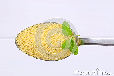 Spoon of raw couscous Stock Photo