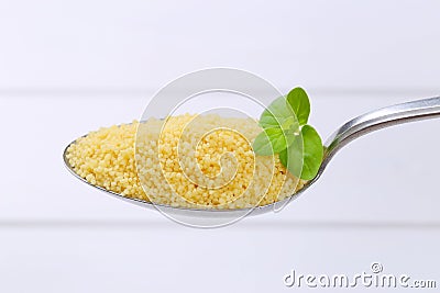 Spoon of raw couscous Stock Photo