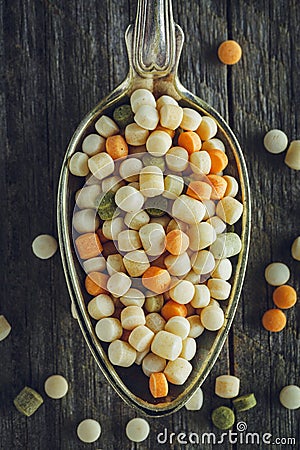 Spoon of raw couscous on a wooden background Stock Photo