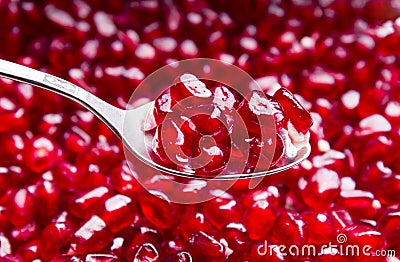 Spoon and red pomegranate seeds Stock Photo