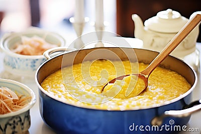 spoon swirling in a pot of golden risotto milanese Stock Photo