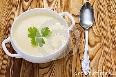 A spoon and tasty potato soup with a leaf of parsley, rustic wooden table. Potato and onion vegan, vegetarian healthy cream soup i Stock Photo