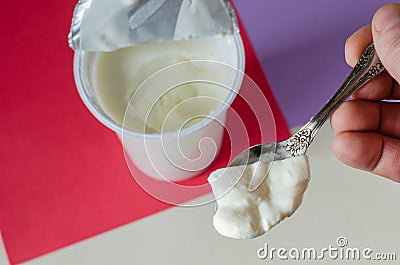 Spoon tasty yogurt in a man`s hand Stock Photo