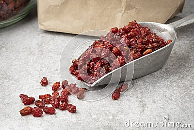 Spoon withf dried Iranian barberries in front of a paper bag Stock Photo