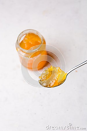 Spoonful of fruit jam with a bottle in background Stock Photo