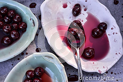 Spoonful of sour Morello cherries on vintage ceramic platter Stock Photo