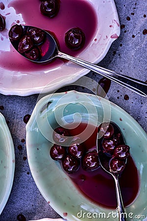 Spoonful of sour Morello cherries on vintage ceramic platter Stock Photo