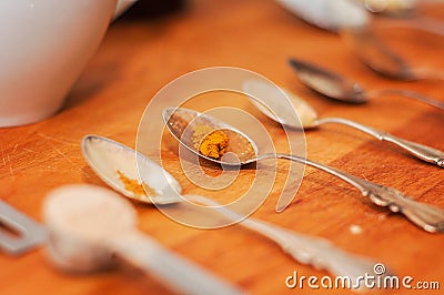 Spoons and spices on a wooden chopping board: spices like turmeric, black pepper, chili, cinnamon, maca, cardamom and ashwagandha Stock Photo