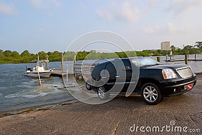 Truck launching fishing boat at ramp Stock Photo