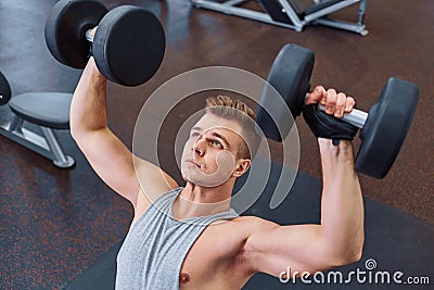 Sport, bodybuilding, training and people concept - young man with dumbbell flexing muscles. men working with dumbbells his body at Stock Photo