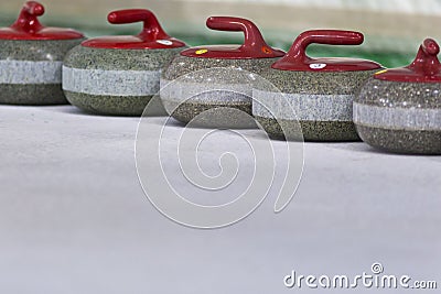 Sport Concepts. Closeup of Curling Red Handle Stones on Ice. Stock Photo