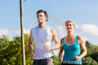 Sport couple running and jogging on rural street Stock Photo