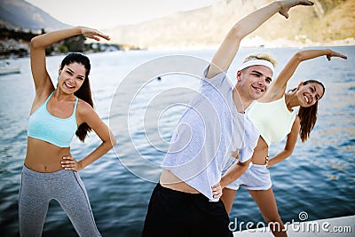 Group of happy people exercising outdoor. Sport, fitness, friendship and healthy lifestyle concept Stock Photo
