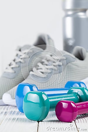 Sport and fitness - sports shoes, water and dumbbell on wooden w Stock Photo