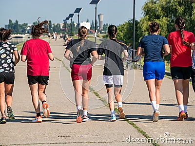 Sport girls team training or running. Girls jogging in a a park Editorial Stock Photo