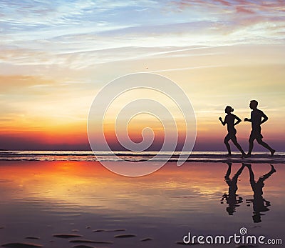 Runners on the beach, silhouette of people jogging at sunset, healthy lifestyle Stock Photo