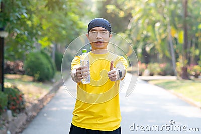 Sport man drinking water bottle in park. Stock Photo