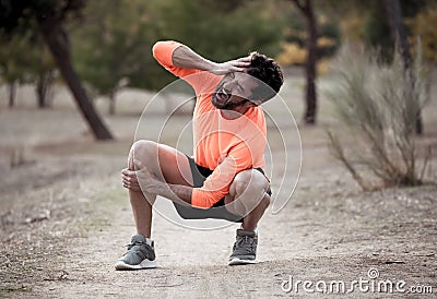 Sport man injured when exercising or running holding his knee screaming in pain Stock Photo