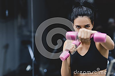 Sport, people and liefstyle concept. Horizontal close-up portrait of strong young woman doing exercise with dumbbells. Fitness Stock Photo