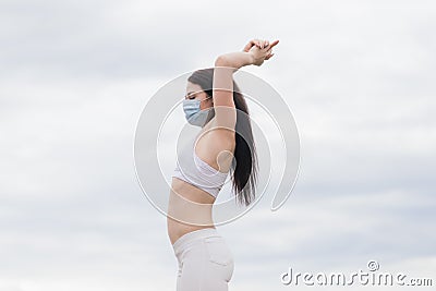 Sport during quarantine, coronavirus, covid-19. Young athletic woman wearing medical protective mask Stock Photo