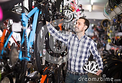 Sport racer is choosing in sports store convenient bike Stock Photo