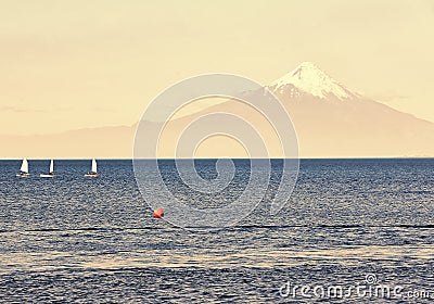 Sport sailing yachts in regatta in the lake Llanquihue on the background of the volcano Osorno in Chile, South America Stock Photo