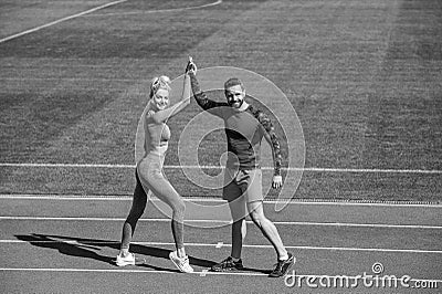 Sport success. male and female coach on stadium running track arena. healthy lifestyle. sport couple celebrate team win Stock Photo