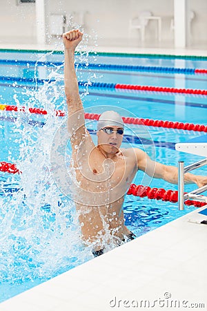 Sport swimmer winning. Man swimming cheering celebrating victory success smiling happy in pool wearing swim goggles and Stock Photo