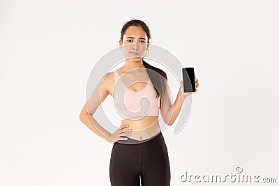 Sport, technology and active lifestyle concept. Dissatisfied and skeptical asian female athlete, sportswoman complaining Stock Photo